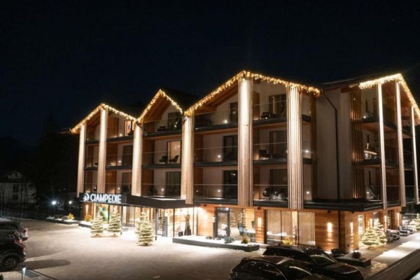 Moderní horský hotel ve tmě osvětlený vánočními světly.