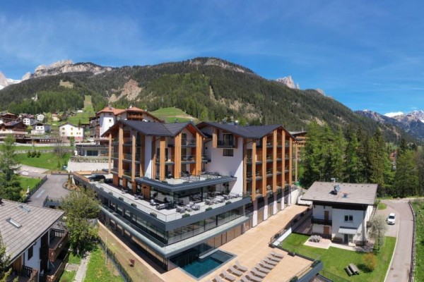 Hotel s bazénem uprostřed horské krajiny.