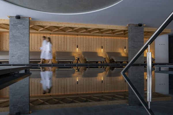 Relaxační zóna s lehátky a bazénem v moderním spa interiéru.