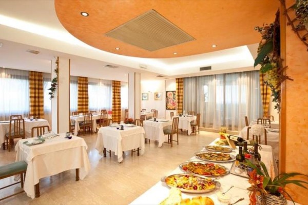 Restaurace s prostřenými stoly a bufetovým stolem s jídlem.