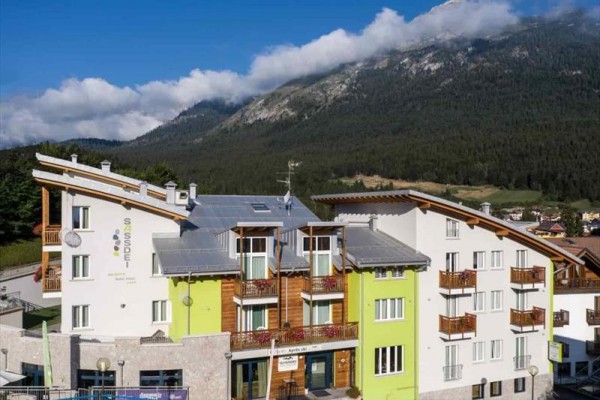 Moderní budova hotelu s horami v pozadí.
