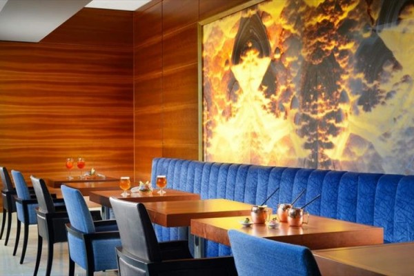 Moderní restaurace s modrými židlemi a stoly s nápoji.