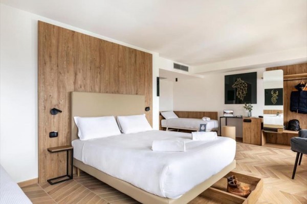 Moderní hotelový pokoj s dvoulůžkem a dřevěným designem.