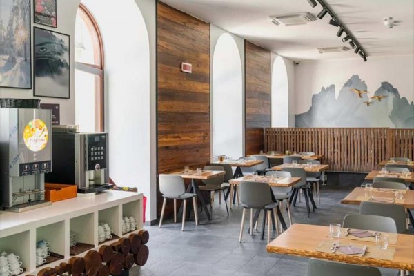 Restaurace s moderním nábytkem a nápojovým automatem.