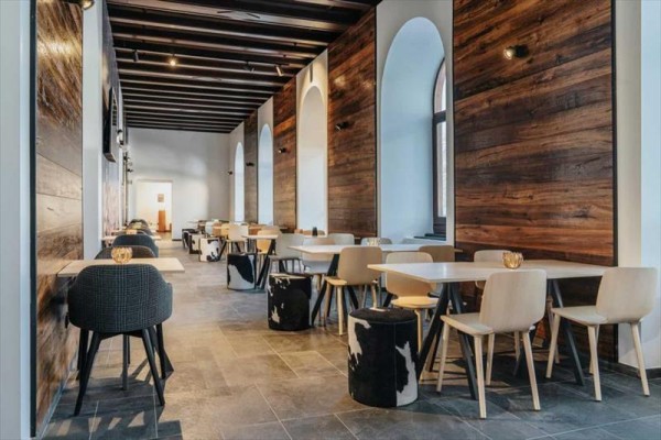 Moderní interiér restaurace s dřevěnými stěnami a minimalistickým nábytkem.
