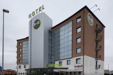 Moderní vícepatrový hotel B&B s prosklenou fasádou a hnědými cihlovými zdmi.