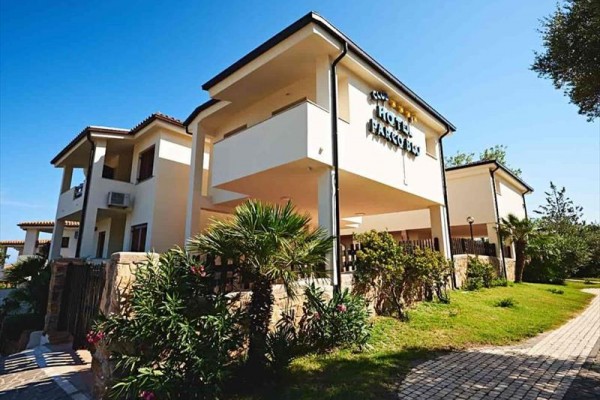 Moderní budova hotelu obklopená zelení.