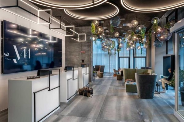 Moderní recepce s designovými světly a pohodlným posezením.