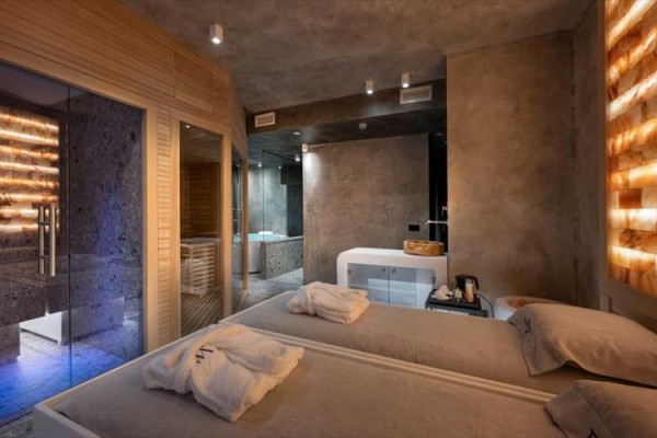 Luxusní wellness pokoj s masážními lůžky, saunou a vířivkou.