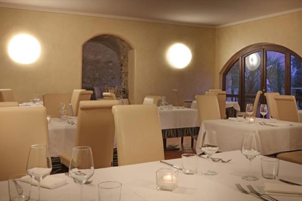 Restaurace s elegantně prostřenými stoly a velkými okny.  