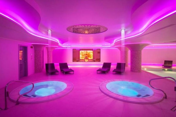 Luxusní wellness centrum s vířivkami a růžovým osvětlením.
