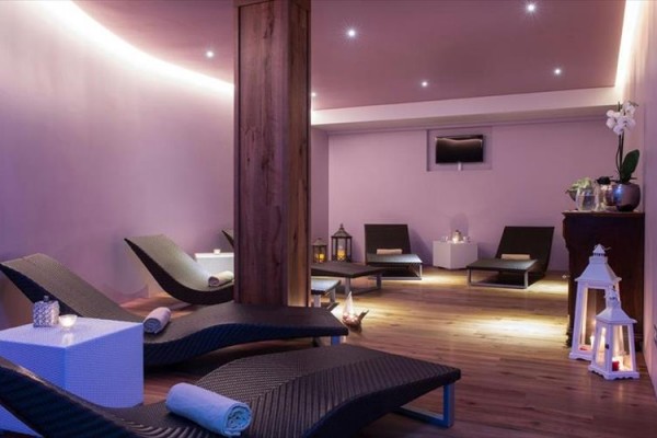 Relaxační místnost se třemi lehátky, svíčkami a jemným osvětlením.  