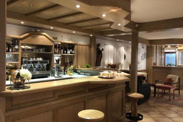 Stylový dřevěný bar s nápoji a kávovarem v elegantní restauraci.