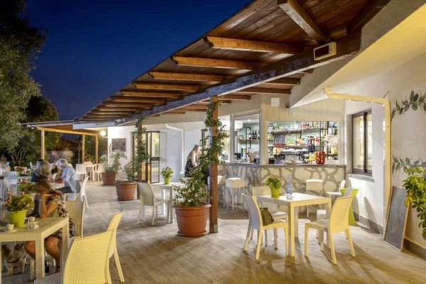 Restaurace s venkovním posezením večer za tmy.