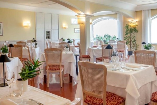 Elegantní restaurace s prostřenými stoly a květinovou výzdobou.