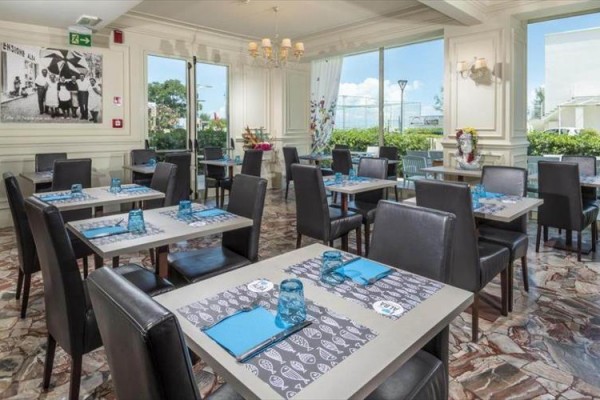 Elegantní restaurace s prostřenými stoly a koženými židlemi.