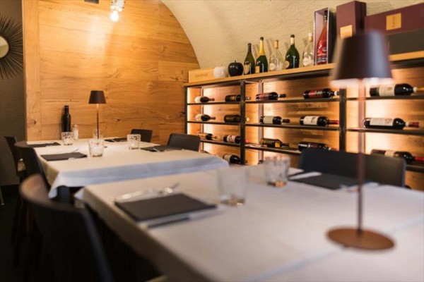 Restaurace s dřevěnými stěnami a policemi plnými vín.