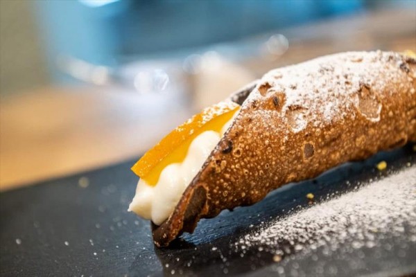 Tradiční italské cannoli plněné smetanovým krémem a zdobené cukrem.