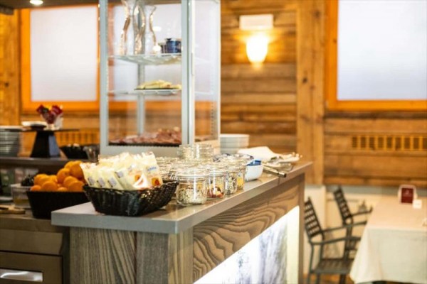 Interiér restaurace s pultem plným jídla a nápojů.