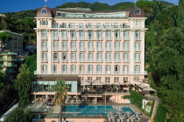 Velký hotel se nachází v hornaté oblasti s bazénem v popředí.
