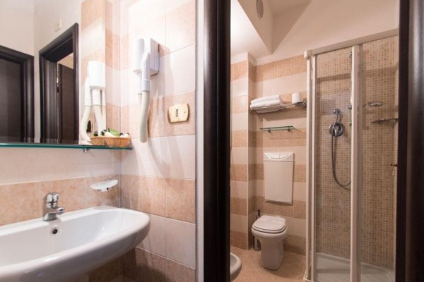 Moderní koupelna s umyvadlem, sprchovým koutem a WC.