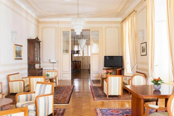 Elegantní místnost s dřevěným nábytkem, koberci a lustry.