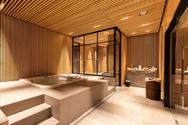 Luxusní wellness prostor s vířivkou a dřevěným obložením.