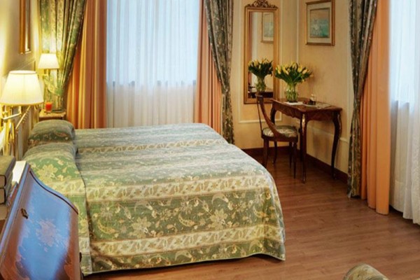 Elegantní ložnice s manželskou postelí a dřevěným nábytkem.
