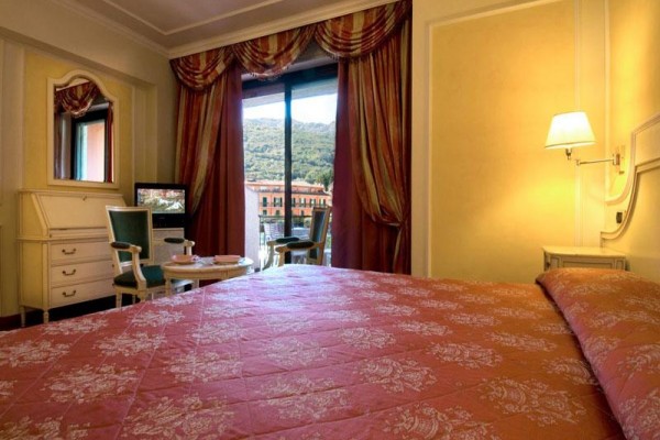 Elegantní ložnice s výhledem na horskou krajinu přes velké okno.