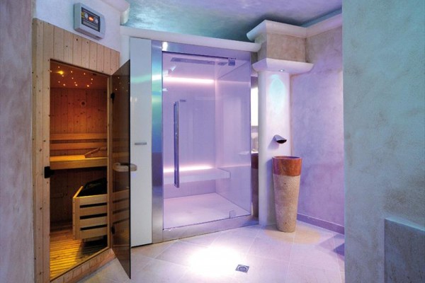 Spa místnost s finskou saunou a prosklenou parní kabinou.