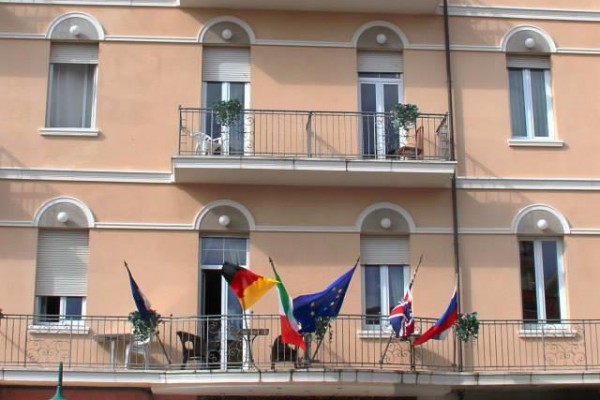 Fasáda hotelu s názvem Stella d'Italia ozdobená vlajkami.