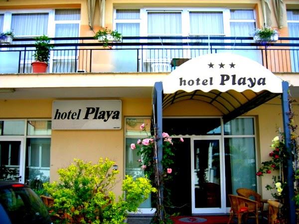 Vchod do hotelu Playa s nápisem a květinovou výzdobou.