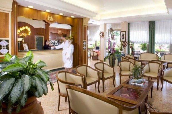 Recepce hotelu s pohodlným posezením a hosty u pultu.