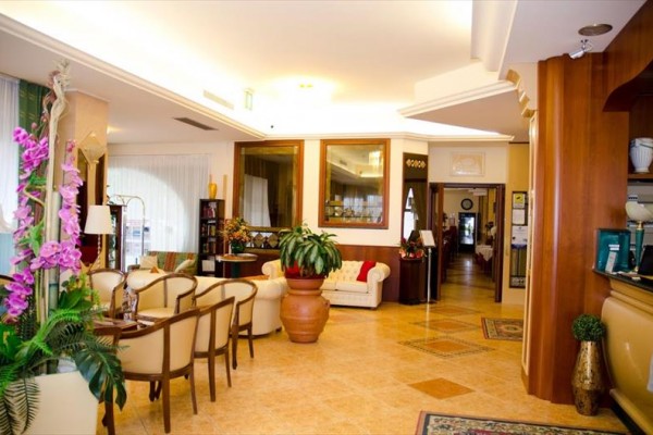 Elegantní hotelová lobby s pohodlným posezením a květinovou výzdobou.