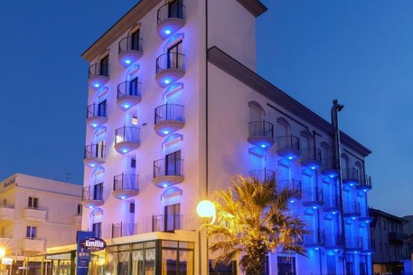 Budova hotelu osvětlená modrým světlem večer.