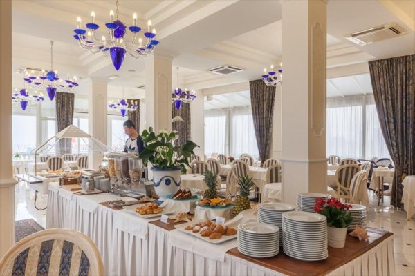 Elegantní restaurace s bufetovým stolem, na kterém je ovoce a pečivo.