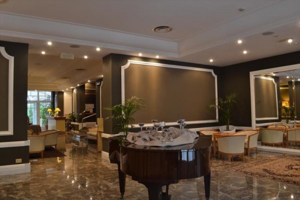 Elegantní hotelová lobby s klavírem a zrcadlem.