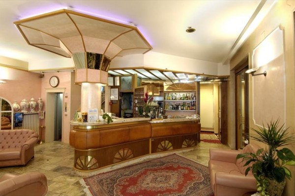 Recepce hotelu s barem a koženými pohovkami.