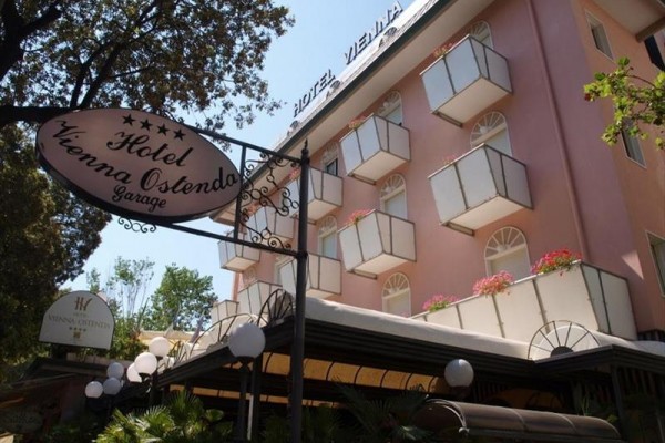 Růžový hotel s balkony a cedulí označující pětihvězdičkový Hotel Vienna Ostenda.