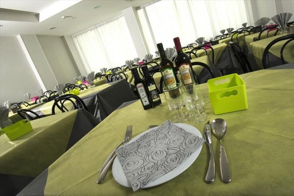 Prostřený stůl s lahvemi vína a nádobím v restauraci.