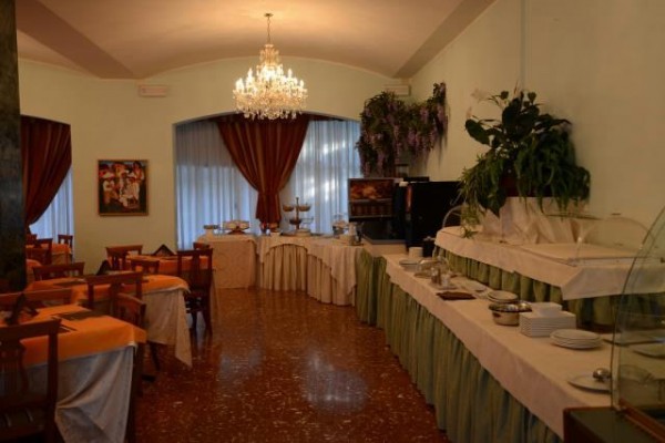 Elegantní jídelna s lustrem, závěsy a bufetovým stolem.