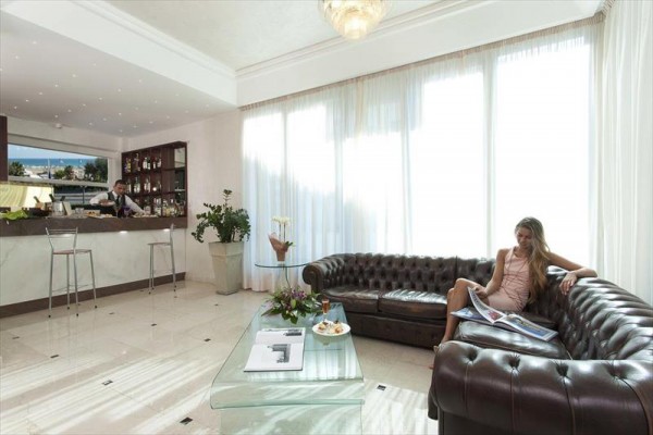 Elegantní hotelová lobby s koženou pohovkou a barem.