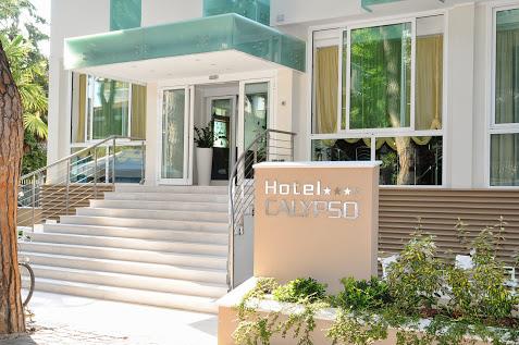 Vstup do moderního hotelu s nápisem Hotel Calypso a čtyřmi hvězdičkami.