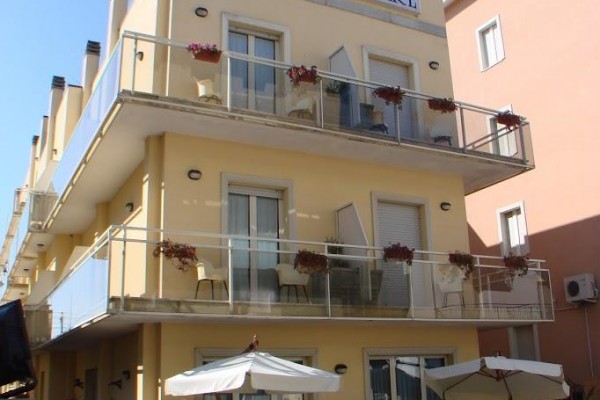 Třípatrový žlutý hotel s nápisem 