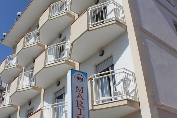 Budova hotelu s několika balkony a nápisem 