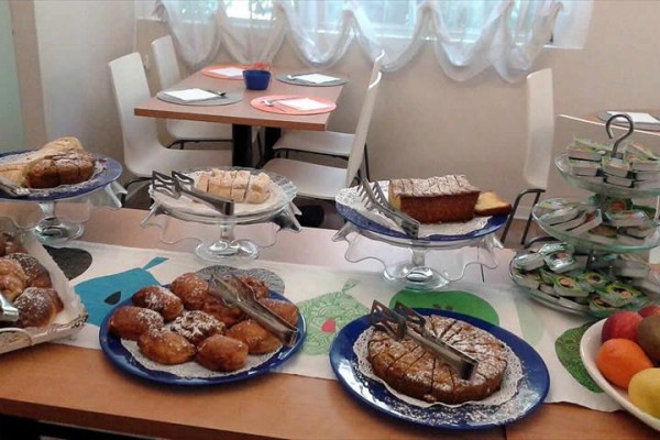 Stůl s různými zákusky a ovocem v interiéru restaurace.