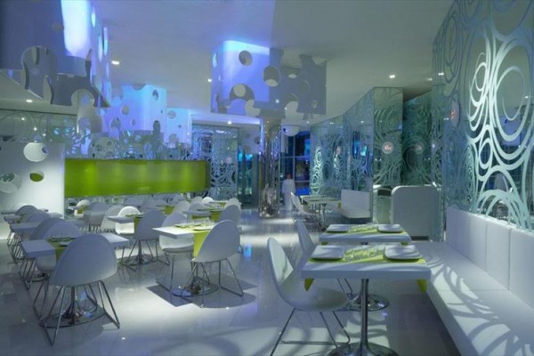 Moderní restaurace s futuristickým designem a modrým osvětlením.