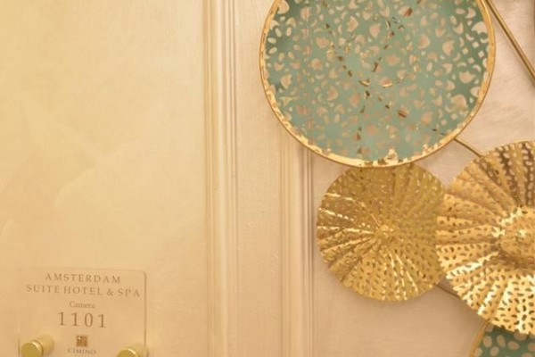 Zlaté a modré dekorace na stěně vedle dveří pokoje 1101 hotelu Amsterdam Suite Hotel & Spa.