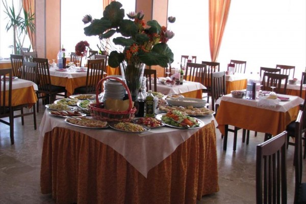 Kulatý stůl s občerstvením a květinami v restauraci.