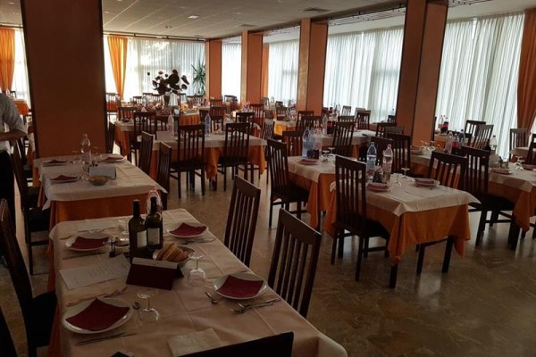 Restaurace s prostřenými stoly a židlemi, připravená k obsluze hostů.